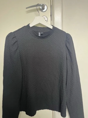 Svart långärmad blus - Säljer en svart långärmad blus med puffärm och rundad hals. Den är köpt på vero-moda men märket är Pieces. Säljer då den inte längre kommer till användning.💞