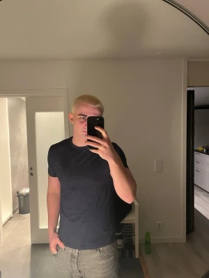 Mörkblå t-shirt från H&M - En enkel och stilren mörkblå t-shirt från H&M. Klassisk rund halsringning och korta ärmar. Perfekt basplagg i garderoben, tillverkad i mjuk bomull för skön komfort.