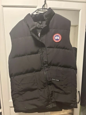 Svart dunväst från Canada Goose - Snygg svart dunväst från Canada Goose! Används ej därav till salu! Använd endast fåtal gånger, alltså nyskick fortfarande! Vid fler frågor och bilder kom PM! Priset är inte hugget i sten!!