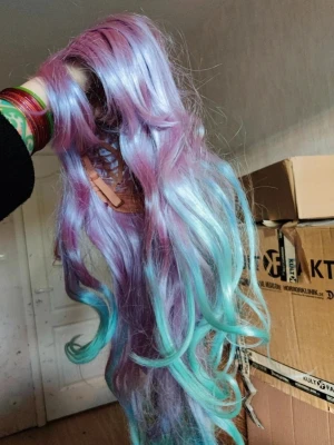 Pastellfärgad cosplayperuk vågig cosplay Lolita kawaii  - Lång vågig peruk i pastellfärger, med mjuka övergångar från lila till turkos. Perfekt för cosplay, maskerad eller festival. Syntetmaterial som ger ett glansigt och färgstarkt intryck. Peruken har en naturlig volym och är lätt att styla.