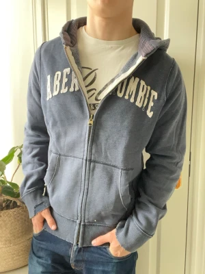 Abercrombie and fitch full zip  - Abercrombie and fitch full zip - designen är vintage. Så sliten på varje ”kant”, Inga defekter! Modellen i bilderna är 180 cm 75 kg och bär Storlek L, lite stor på modellen. Kom med frågor! 🌟 (Kan gå ned i pris vid köp av paket 😉) 