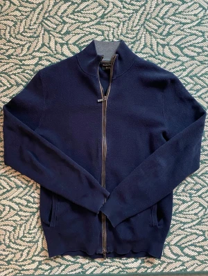 Massimo Dutti Full Zip Tröja Mörkblå - En mörkblå zip tröja från Massimo Dutti. OBS! Står M i tröjan men skulle säga att den passar som S! Jag har vanligtvis M och den sitter väldigt tight på mig