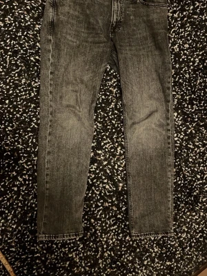 Jack Jones 32/32 - Säljer ett par grå tvättade skinny jeans med klassisk femficksmodell och raka ben. Jeansen har en snygg slitningseffekt och normal midja. Perfekta till en avslappnad streetwear-look.