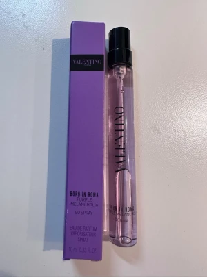 Valentino Born In Roma Purple Melancholia - Valentino Born In Roma Purple Melancholia Eau de Parfum i en smidig 10 ml sprayflaska. Flaskan är cylinderformad i transparent lila glas med svart spraykork. Kommer i en snygg lila kartong med tydlig logga. Perfekt att ha med i väskan.