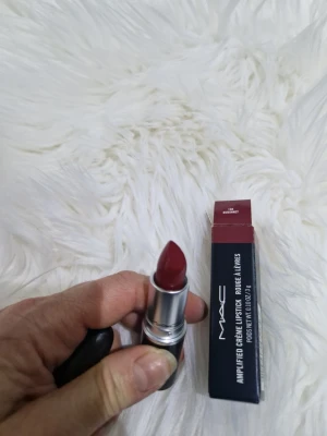 MAC Amplified Creme Lipstick Dubonnet - Snyggt mörkrött läppstift från MAC i nyansen Dubonnet. Läppstiftet har en krämig formula och kommer i ett stilrent svart hylsa med silverdetaljer. Perfekt för dig som vill ha en djup röd färg med glansig finish. Originalförpackning medföljer.