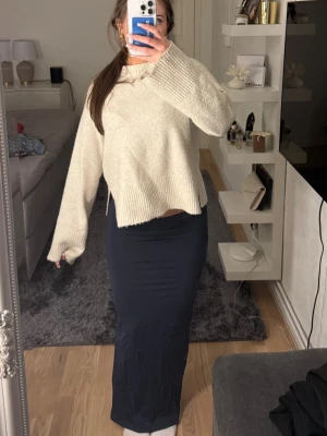 Mörkblå långkjol med slits - Säljer en stilren mörkblå långkjol med slits på sidan. Kjolen har en tight passform och är gjord i ett mjukt, stretchigt material. Inga skador!