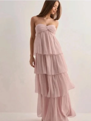 Ljusrosa bal/sommarklänning - Klänningen har en lätt och luftig känsla, perfekt för speciella tillfällen. Söt detalj med rynk framtill vid bysten. Knytet går att ljusters och använda som en sjal eller som att koppla samman med klänningen och ha runt halsen. (Enbart använd 1 gång)