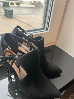 Svarta stövletter från Tiger of Sweden - Säljer ett par svarta stövletter från Tiger of Sweden i mocka. Skorna har spetsig tå, snörning baktill och klack. Snygg och stilren design som passar till många olika outfits.