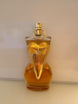 Jean Paul Gaultier Classique parfym - Unik parfymflaska från Jean Paul Gaultier le parfum med guldiga detaljer och konstnärlig design. Flaskan har en elegant, kurvig form och är dekorerad med en iögonfallande guldfärgad metallapplikation framtill. Perfekt för dig som gillar lyxiga och kreativa dofter. 100 ml. Ordinarie pris 1819. Helt oanvänd.