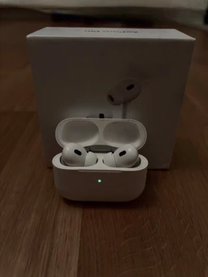 Apple AirPods Pro trådlösa hörlurar - *OBS! Ljudet i högra AirPoden fungerar ej, men resterande funktioner fungerar som vanligt.*Snygga vita Apple AirPods Pro med laddningsetui. De har en stilren och kompakt design, silikonproppar för bra passform och brusreducering. Perfekta för musik, poddar och samtal. Levereras med originalförpackning. Övrigt skick ~ 7,5/10 
