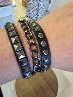 Punkarmband svart/silver - Punkarmband svart/silver. Kedja i mitten. 22,2 cm långt. Bredd 2,7 cm.