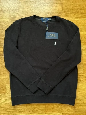 Polo Ralph Lauren tröja svart - Klassisk svart sweatshirt från Polo Ralph Lauren med rund halsringning och den ikoniska vita logobroderingen på bröstet. 😎 (100% bomull) Priset kan diskuteras! (Skicka bud)💯
