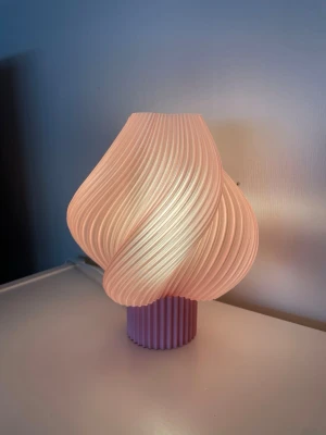 Bordslampa 21cm rosa/ ljusrosa - Säljer en lampa som är 21cm hög inkl foten och 17cm bred. Ingår sladd som är 4m med sockel e14.  Led lampa ingår inte. Endast led lampa rekommenderas. Lampan är tillverkad av plast.