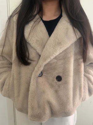 Beige kort pälsjacka (ord:300kr) accepterar bud 💕 - Säljer en supermjuk och fluffig beige pälsjacka i kort modell. Jackan har stora slag, dubbelknäppning med två knappar och sidofickor. Perfekt för att hålla sig varm och snygg under kalla dagar. Skulle passa till dig som vill ha en fin och mjuk kappa till vinter där du kan både visa dina fina looks och hålla dig varm❤️