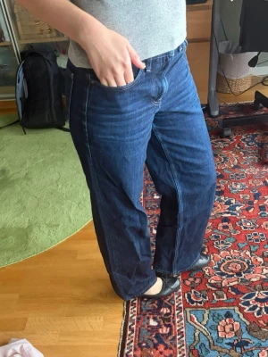 Mörkblå raka jeans - Säljer ett par mörkblå jeans med rak passform och klassisk femficksdesign. Jeansen har medel midja . Hör av dig vid frågor!