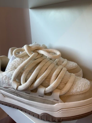 Chunky vita sneakers med teddy-detaljer från BERSHKA - Snygga chunky sneakers i vitt med breda krämvita skosnören och teddy-material på ovandelen från BERSHKA. Skorna har detaljer i beige mocka och en kraftig sula i vitt och brunt. Perfekta för dig som gillar streetstyle och vill sticka ut med en unik look. Helt nya. 