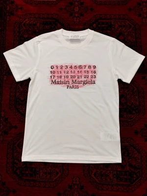 Maison Margiela t-shirt - Vit och sällsynt t-shirt  från Maison Margiela perfekt för sommar outfits. | skick : 10/10 har endast använts fåtal gånger så ser ut som ny. | etiketten och påsen följer med på köp! | Storlek EU S| längd : 64 cm | bredd : 46 cm | pris går att diskutera vid bundle köp / snabbaffär! 💯