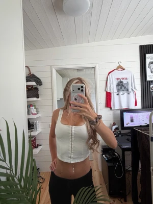 Korsettstil topp - Säljer en vit croppad topp med breda axelband och fyrkantig urringning. 