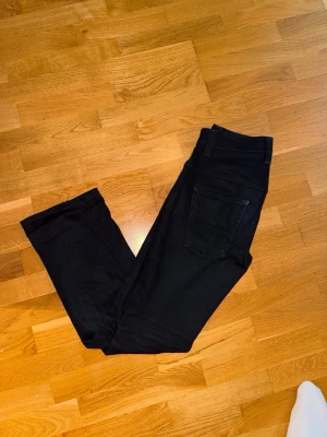 Nudie Jeans, Svart - Klassiska Svarta Nudie jeans för män. Skick: Mycket bra skick, inga skador/slitage. Storlek: Waist 28 / Lenght 30. Hör av dig vid intresse/frågor. PRIS KAN DISKUTERAS!