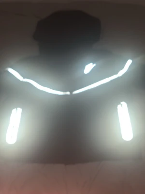 Svart Nike hoodie med reflexdetaljer - Säljer en svart hoodie från Nike med dragkedja och huva. Hoodien har vita reflexdetaljer längs bröstet och vid fickorna samt en vit Nike-logga på bröstet. Perfekt för dig som vill sticka ut lite extra i mörkret. Klassisk och sportig design. Storleken är XL för barn
