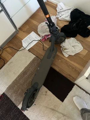 Svart elscooter med handbroms - Säljer en svart elscooter med bred fotplatta och handbroms. Scootern har en digital display på styret och gummihandtag för bra grepp. Laddare medföljer. Perfekt för att ta sig runt i stan på ett smidigt sätt.
