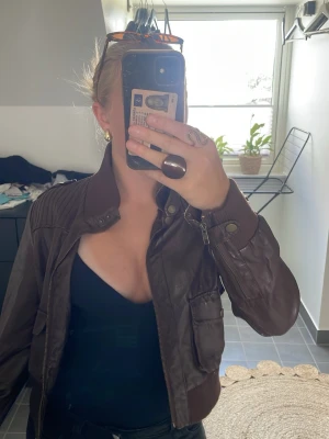 Mörkbrun skinnjacka med hög krage - Vintage Y2K brun bomberjacka, moto jacket, faux leather, oversized, 90s/2000s aesthetic. Jackan är förvånande i storlek L men passar för S. Den flagnar lite i kragen vid nacken!