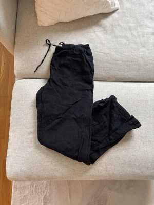 Linnebyxor  - Ett par svarta linnebyxor med avslappnad passform från GinaTricot. Byxorna har resår i midjan och är vida i benen. Mycket bra skick, har förmodligen bara använt dom en gång och därefter blivit liggandes i garderoben.