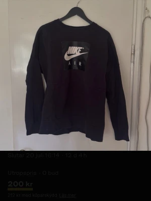 Svart Nike Air sweatshirt - Svart sweatshirt från Nike Air med stor vit logga på bröstet. Tröjan har rund halsringning, långa ärmar och ribbade muddar vid ärmslut och nederkant. Perfekt för en sportig och avslappnad stil.