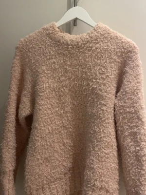 Ljusrosa fluffig stickad tröja - Supermjuk och fluffig stickad tröja i ljusrosa färg. Tröjan har lång ärm, rund halsringning och en oversized, avslappnad passform. Jätte gosigt material enligt mig och säljer endast för att jag behöver ha lite mer utrymme.