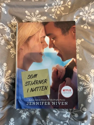 Som stjärnor i natten av Jennifer Niven - En svenskutgåva av romanen 'Som stjärnor i natten' av Jennifer Niven. Omslaget har ett foto med blå och beige toner och en gul post-it-lapp med titeln. Boken är inbunden och baserad på filmen 'All the Bright Places' som finns på Netflix.