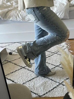 Silvriga sneakers - Säljer ett par silvriga sneakers med svarta detaljer i storlek 39🤍De har dragkedja på insidan av skon. 