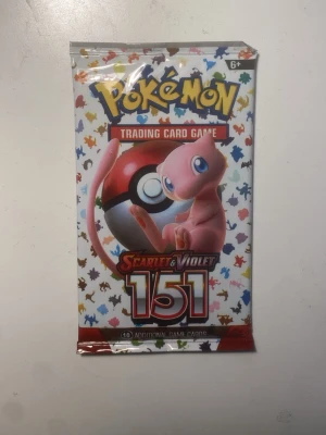 Pokémon Scarlet & Violet 151 booster - Pokémon boosterpack från Scarlet & Violet 151-serien. Förpackningen är vit med färgglada siluetter av olika Pokémon och har Mew och en Pokéball på framsidan. Innehåller 10 samlarkort till Pokémon Trading Card Game.