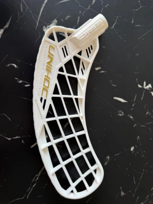 Innebandyblad Unihoc - Vitt innebandyblad från Unihoc, modell Epic. Plasten är PE. Helt oanvänt som bara legat med original hook. 