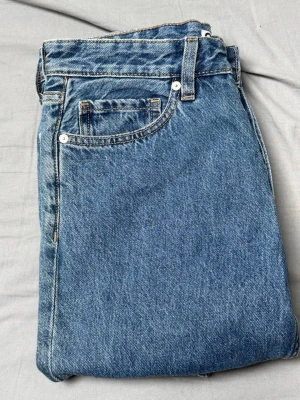 Blå raka Cubus jeans med fina detaljer - Klassiska blå jeans från Cubus i rak modell. Jeansen har fem fickor, bälteshällor och stängs med dragkedja och knapp. Tillverkade i slitstark denim med en tidlös tvätt som passar till det mesta.