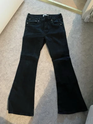 Svarta ”snake flare” jeans från 157 - Säljer ett par svarta flare jeans från 157 med klassisk femficksmodell och utsvängda ben. Jeansen har bälteshällor och knappgylf. Perfekta för dig som gillar retrovibbar och vill ha en snygg siluett. Använd en gång och säljer då dem är för stora för mig! Ungefärlig storlek ~ 42. Inte 40 (L) utan defekter. Sista bilderna är en REFERENS inte riktiga byxorna (hittar dom inte 😪) original pris 200kr. Säljer för 150 så det är iprincip helt nya.