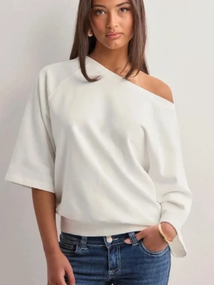 Vit offshoulder topp - Trendig vit offshoulder topp med lös passform och trekvartsärm. Perfekt för dig som gillar en avslappnad men ändå stilren look. Tillverkad i mjukt material som känns skönt mot huden.