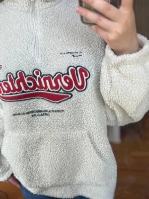 Oanvänd krämvit teddytröja / sherpa half zip – oversized - Säljer en supermjuk och helt oanvänd teddytröja / sherpa half zip i krämvit färg.  Den har en mysig, fluffig struktur med broderad logga framtill och dragkedja vid kragen. Perfekt som höst-/vintertröja, över en t-shirt eller under jacka när det är kallt. Den ger den där avslappnade, cozy oversized-looken utan att kännas stel.  Passformen är mjuk och bekväm med lite lösare siluett. Väldigt fin till jeans, leggings eller mjukisbyxor.  Skick: aldrig använd Färg: krämvit/off-white Modell: teddy/sher