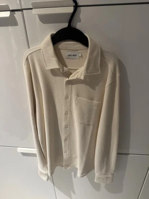 Beige stickad overshirt från East West - Säljer denna beiga overshirten från East west i storlek S, tröjan är även helt oanvänd.