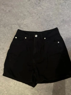 Svarta shorts  - Snygga svarta shorts med klassisk femficksdesign. Tillverkade i bomull med knapp och dragkedja framtill. Perfekta för en stilren och enkel look.
