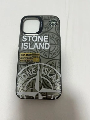 Stone Island skal - Snyggt mobilskal från Stone Island i svart och grått med tydlig logga och coolt mönster. Passar till iPhone 13,14,15 har även andra färger. Hör av er för färgerna