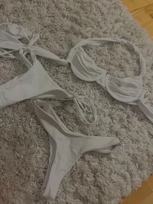 3 st Vit bikini delar  - Snygg vit bikini med bygel-bh och snörning både på toppen och trosorna. Klassisk och stilren modell som passar perfekt till sommaren. Materialet känns mjukt och stretchigt för en bekväm passform.