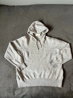 Sayless Kashmir hoddie  - Mjuk och exklusiv stickad hoodie från Sayless i kashmir. Ett stilrent premiumplagg som är både varmt och bekvämt att bära.  Detaljer  * Storlek: XS * Färg: Gråmelerad * Material: Kashmir  Skick  * Fint skick överlag * Mindre hål nertill på vänster sida nära mudden * Priset är anpassat efter anmärkningen  Perfekt för dig som söker en bekväm och lyxig hoodie till ett bra pris.  📦 Skickas snabbt och spårbart.