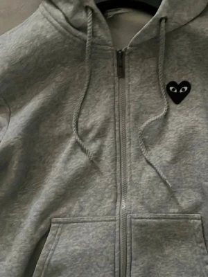 CDG Comme des garcons Play zip hoodie - CDG zip hoodie med svart hjärta framme och stort hjärta på ryggen, endast använd 2-3 ggr den är iprincip som helt ny inga fläckar inga skador. Perfekt till alla årstider/dagar när det behövs en skön hoodie