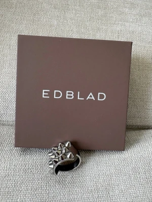 Silvrig ring med nitar från Edblad - Cool ring från Edblad i blankt silverfärgat metallmaterial. Ringen har flera små nitar som ger en snygg och modern look. Perfekt accessoar för dig som vill sticka ut och addera lite attityd till din outfit. KAN SÄNKA PRISET!! Nypris är 449💕💕