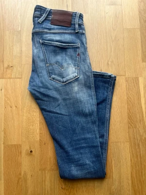 Replay Anbass W28 L32 - Säljer dessa feta Replay Anbass i storlek W28 L32. Jeansen är i fint skick utan defekter med snygga fades, kom PM för mer info/bilder. Priset är ej hugget i sten!