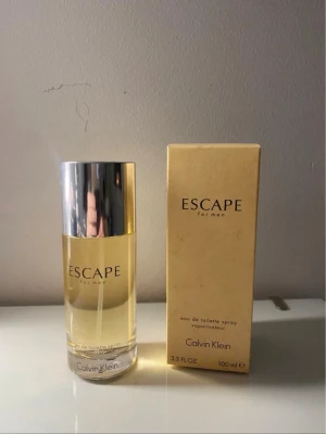 Calvin Klein Escape for Men EdT 100ml - Escape for Men från Calvin Klein är en klassisk eau de toilette i en stilren, den är helt nya och oöppnad förutom vid bilderna. transparent glasflaska med silverfärgat lock. Doften kommer i en beige kartong och flaskan rymmer 100 ml. Perfekt för dig som gillar fräscha och maskulina parfymer.