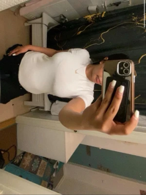 Vit basic t-shirt i bomull - En klassisk vit t-shirt med rund hals och korta ärmar. Tillverkad i mjuk bomull som sitter bekvämt och har en normal passform. Perfekt att matcha med jeans eller shorts för en enkel och stilren look.