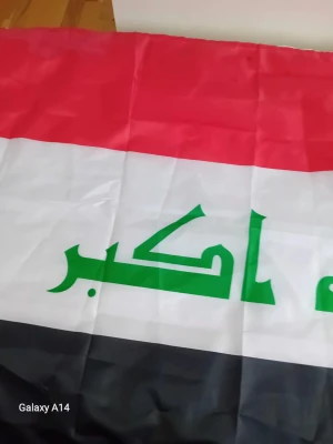 Irakisk flagga i tyg - Säljer en irakisk flagga i tyg med horisontella ränder i rött, vitt och svart samt grön arabisk text i mitten. Perfekt för dekoration eller evenemang. Flaggan har klassisk rektangulär form och tydliga färger. 150cm x 90cm