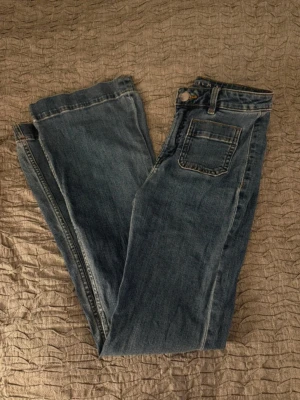 Blå utsvängda jeans  - Populära jeans från Bik Bok. Lite slitna längst ner. Storlek 25 längd 32. 