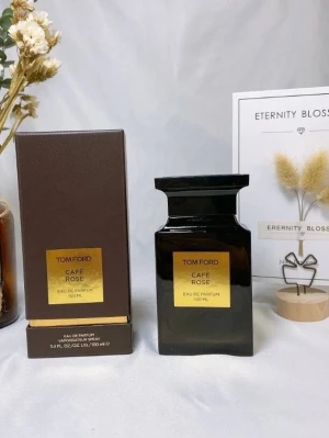 Tom Ford Café Rose Eau de Parfum - Tom Ford Café Rose Eau de Parfum 100 ml i en elegant mörkbrun glasflaska med guldetikett. Flaskan har en fyrkantig form och ett brett, svart lock. Doften kombinerar ros och kaffe för en lyxig och unik parfymupplevelse.